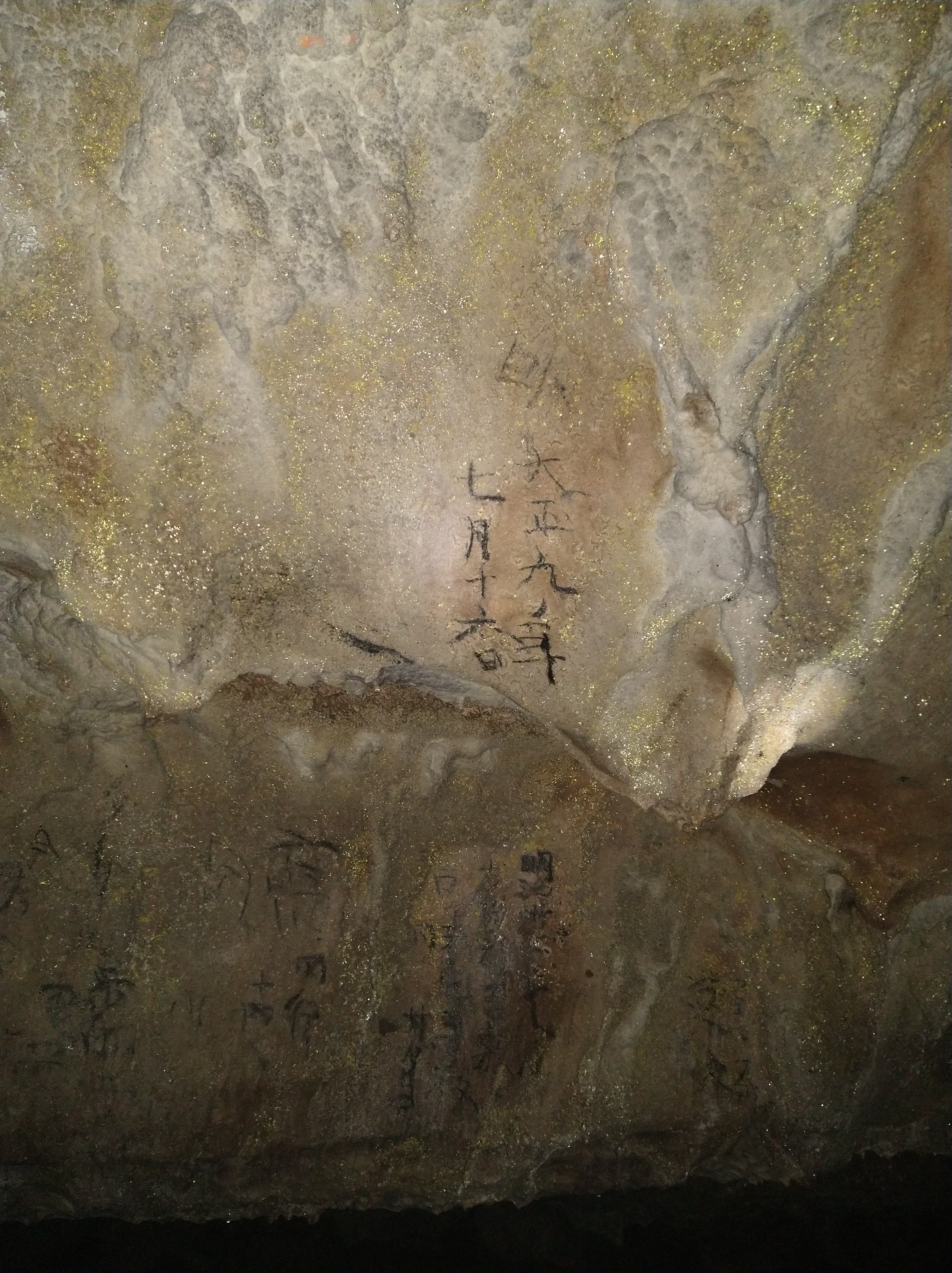 A picture of a rock wall. Japanese characters are written in black.